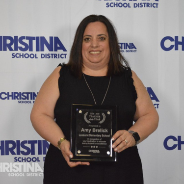 Photo of Amy Brelick holding Teacher of the Year plague